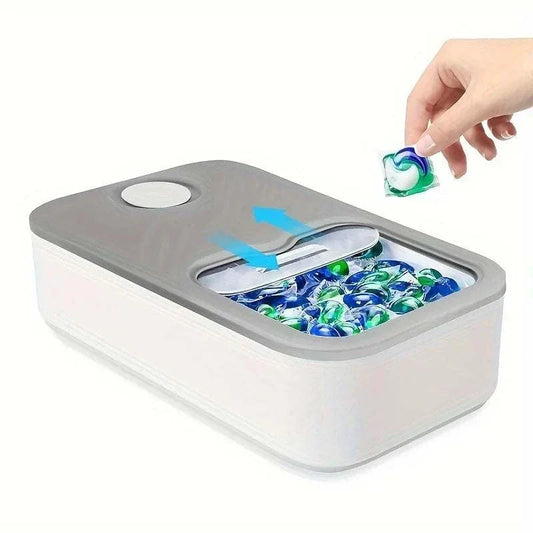 Laundry Pod Container in white with a gray sliding lid, compact rectangular plastic design holding colorful detergent pods.