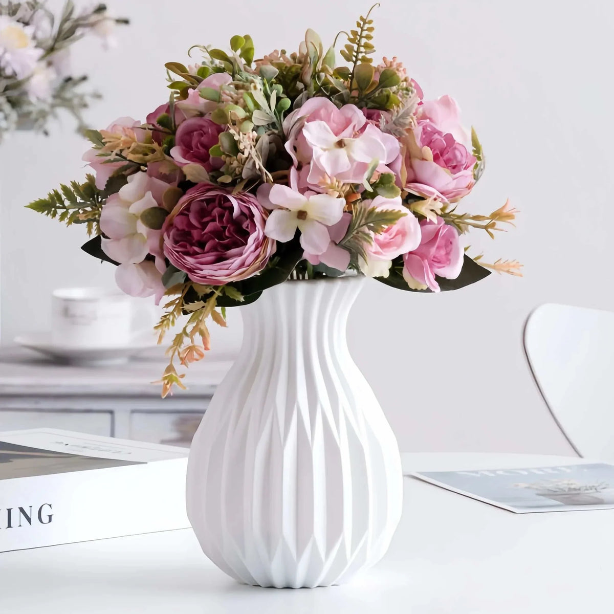 Ceramic Nordic Flower Vase in white with a ribbed texture, holding an arrangement of pink and white artificial flowers with green foliage