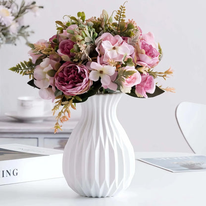 Ceramic Nordic Flower Vase in white with a ribbed texture, holding an arrangement of pink and white artificial flowers with green foliage