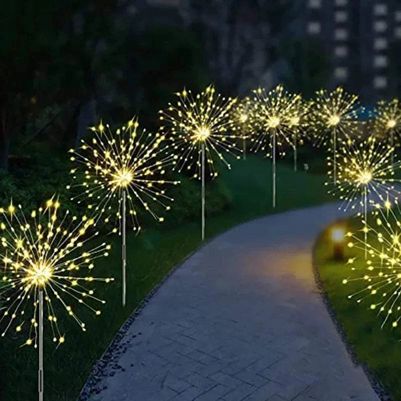 Dandelion Firework Lights featuring warm white LED bulbs arranged in dandelion-like bursts along a garden pathway at night