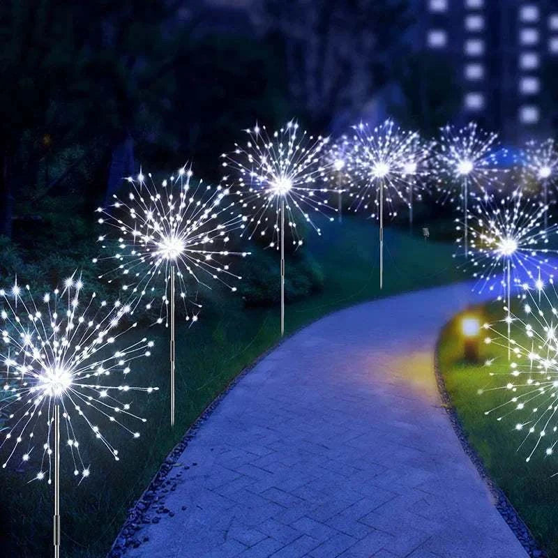 Dandelion Firework Lights with bright white LED bulbs arranged in spherical bursts lining a garden pathway at night
