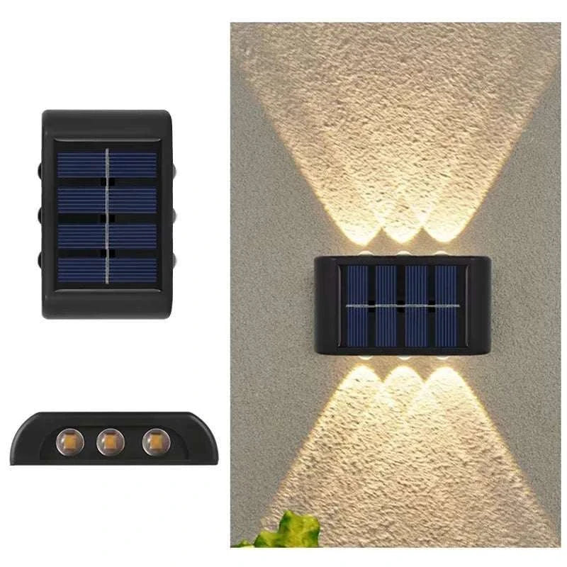 Outdoor Waterproof Fence Lamp in black with solar panel and triple LED lights casting upward and downward beams on a wall