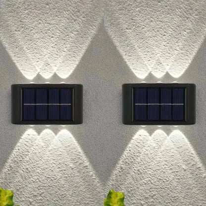 Outdoor Waterproof Fence Lamp with black casing and integrated solar panel, mounted on textured wall, casting upward and downward white light patterns