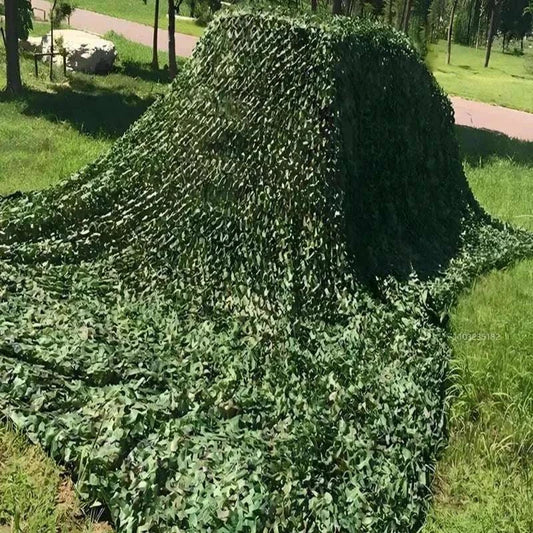Premium Camouflage Netting in green with natural leaf patterns, draped over outdoor object blending with grassy surroundings