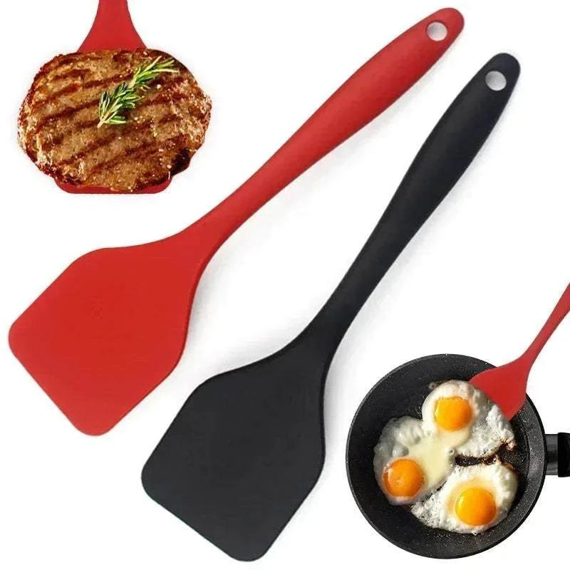 Silicone Cooking Spatula set with one red and one black flexible flat head and ergonomic handles, shown with grilled steak and fried eggs