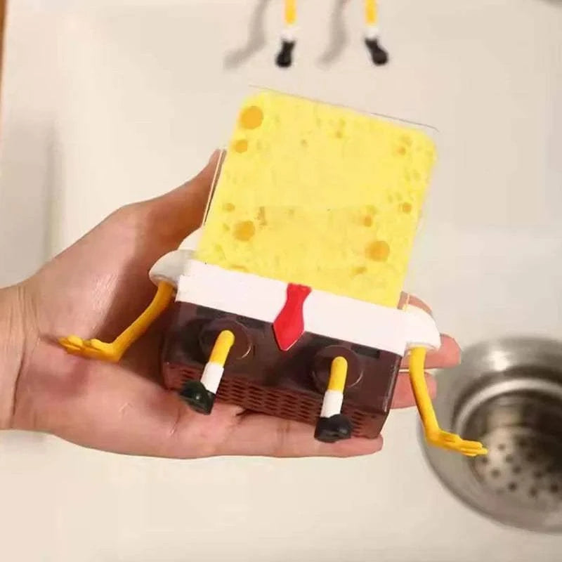 Sink Shelf Drainage rack holding a yellow sponge designed like a cartoon character with arms and legs, placed by a kitchen sink
