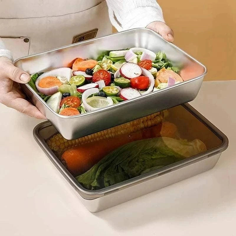 Stainless Steel Food Storage Container with rectangular shape, filled with fresh assorted vegetables and greens, held by hands