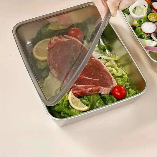 Stainless Steel Food Storage Container with clear lid holding raw steak, lettuce, cherry tomatoes, and lemon slices inside