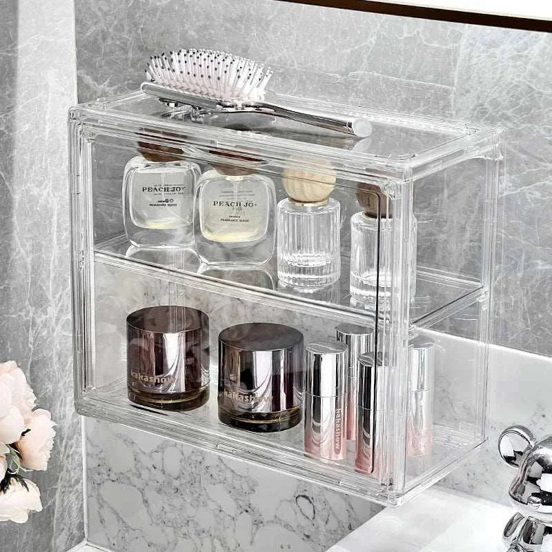 Transparent Acrylic Organizer with two shelves holding cosmetic bottles, jars, lipstick tubes, and a hairbrush on top in a bathroom setting