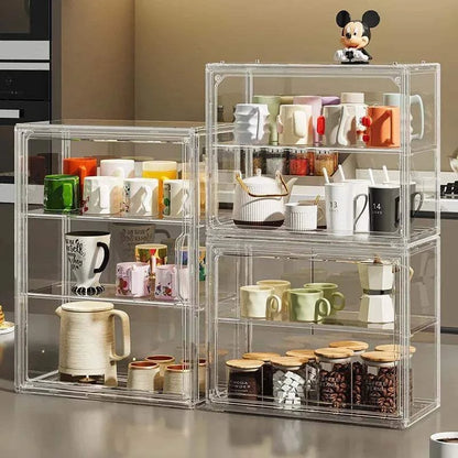 Transparent Acrylic Organizer storage boxes with clear compartments holding colorful mugs, cups, jars, and a small figurine, neat and visible